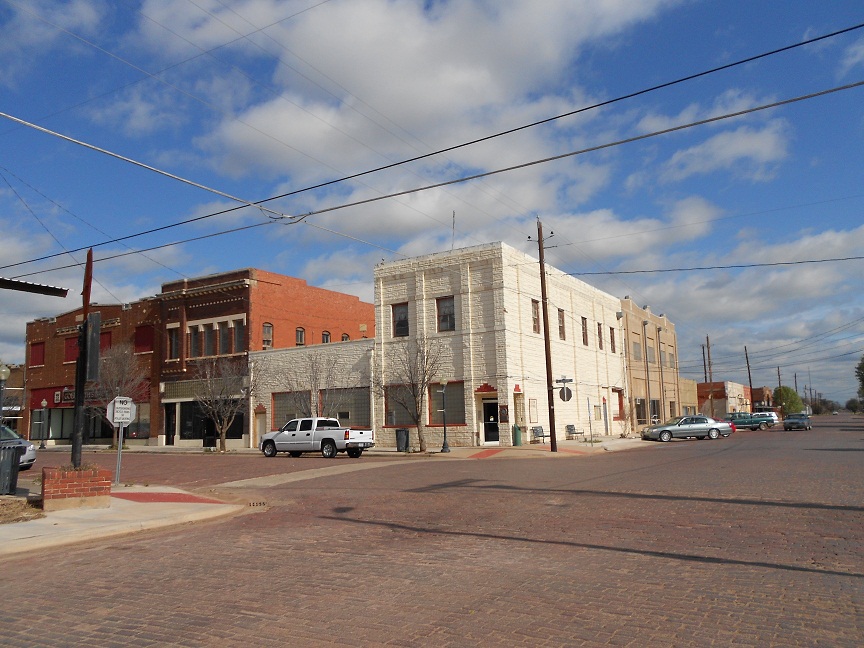 Historic downtown Electra, Texas showing brick-paved streets, two-story commercial buildings, and classic small-town architecture